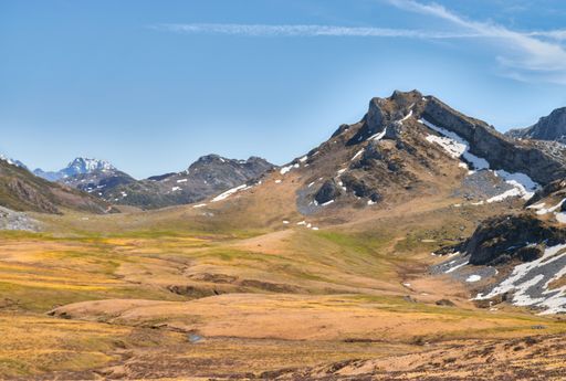 An aerial view of mountain landscape under blue bright sky