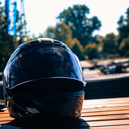 A closeup shot of a black safety helmet on a wooden surface