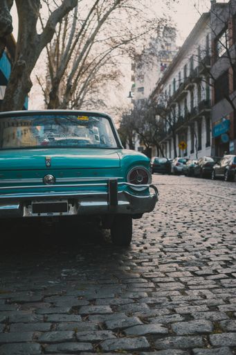 Vertical shoot of an vintage car parked on the cobble street with old style