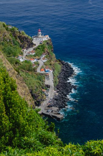 A vertical shot of Arnel Lighthouse by the sea in Sao Miguel, Azores
