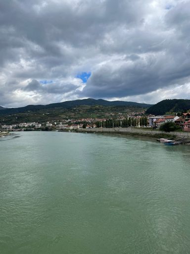 A beautiful city by the river against the background of gloomy clouds