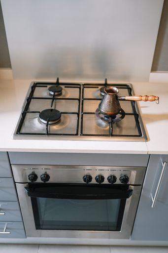 A vertical shot of coffee brewed in a copper Turk on the gas stove
