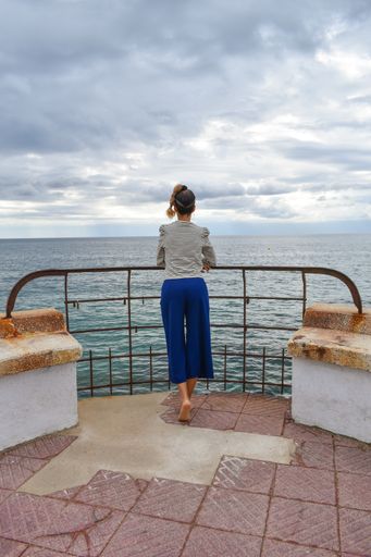 A shot of a woman enjoying the view of a sea