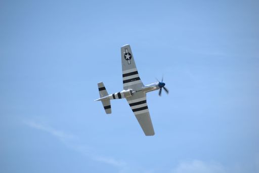 The undercarriage view of a North American P-51 Mustang WWII aircraft flying at Springbank Airport