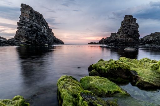 The beautiful rock formations covered with moss at Bulgaria Beach against a cloudy sky