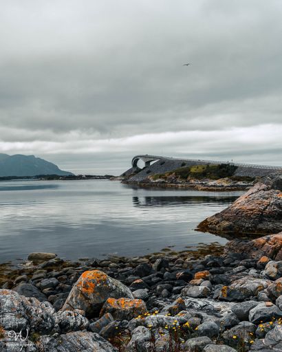 A vertical shot of the beautiful Storseisundet Bridge with a cloudy sky in the background in Norway