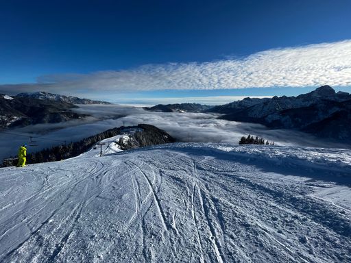 A scenic view of the ski run slope in the mountains above the clouds - winter sport location