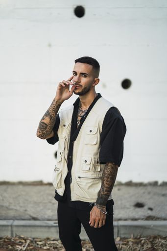 A vertical shot of a handsome male standing near a building