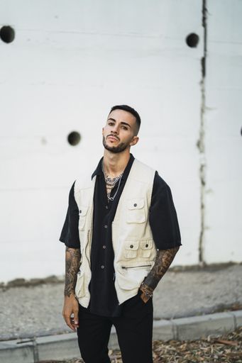 A vertical shot of a handsome male standing near a building