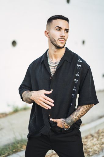 A vertical shot of a young European male with tattoos