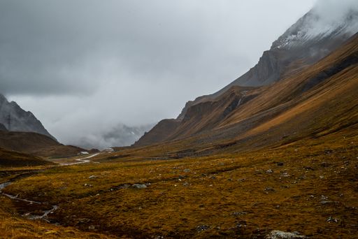 A scenic view of a valley and mountain range on a cloudy autumn day. Albula Alps, Switzerland.
