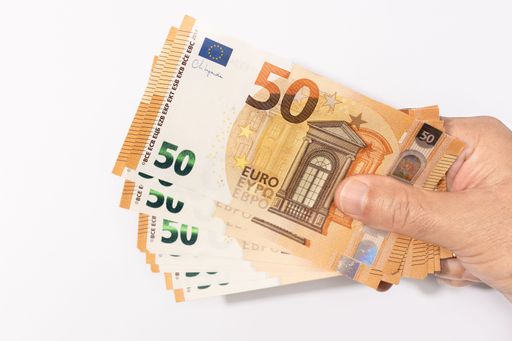 Hand holding many 50 euro banknotes on white background
