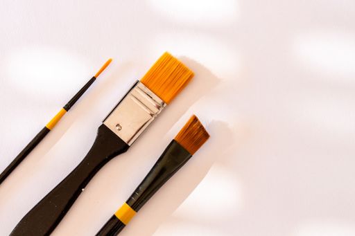 A top view shot of three paintbrushes isolated on white background
