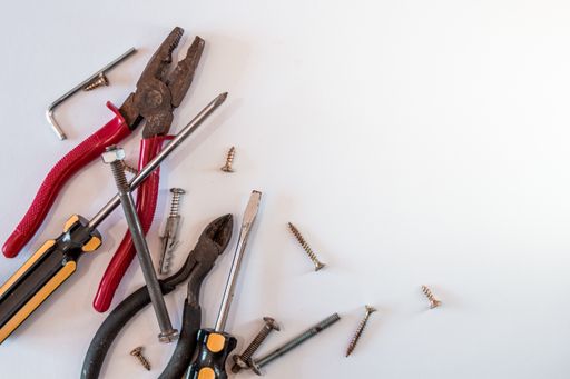 A top view shot of different repair tools on a white table