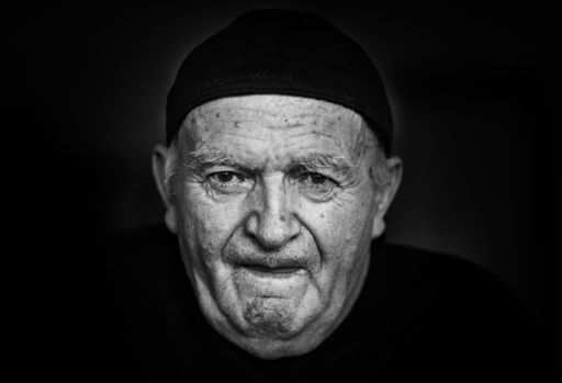An elderly man wearing a black headwrap in grayscale