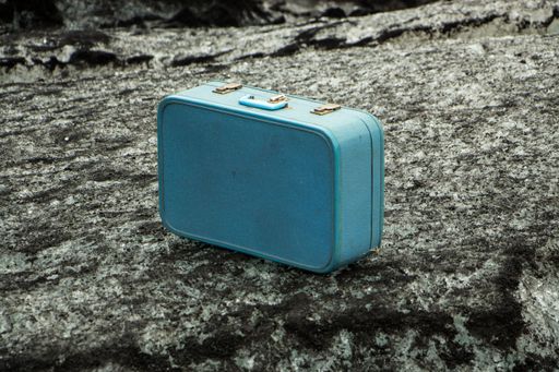 An old blue suitcase on a rock