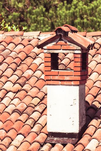 A vertical shot of a brickwork roof and chimney
