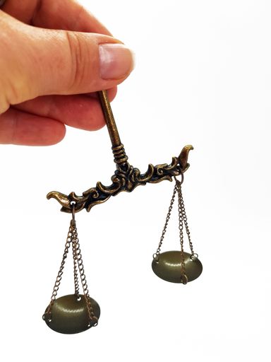 A vertical shot of a hand holding scales on an isolated background