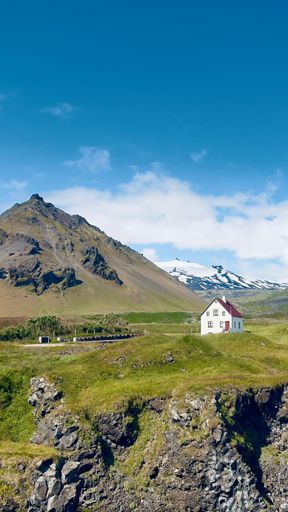 Beautiful view to white house in front of mountain at Arnarstapi fishing village in Iceland Snaefellsnes peninsula