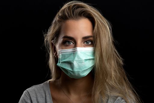 A young Caucasian woman wearing a face mask - the concept of coronavirus