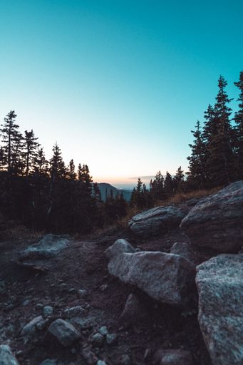 A beautiful vertical aerial view of a sunset over mountains up in the hills with blue sky background