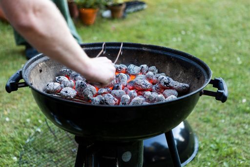 A closeup of a barbecue grill with a burning charcoal