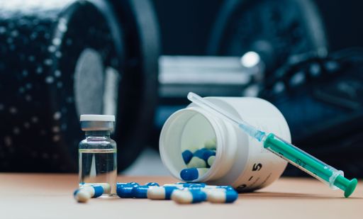 A closeup of illegal doping injectable drug and capsules on a table - cheating drug in sports