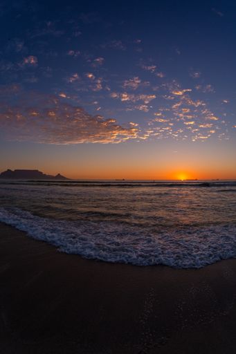 A vertical shot of the sunset over the shore of the famous Table mountain in Cape Town, South Africa