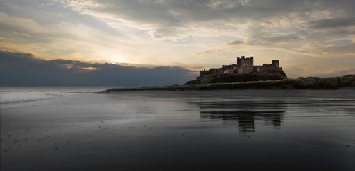 A beautiful shot of a sunset sky over sea with Bamburgh Castle in distance in county of Northumberland ,UK