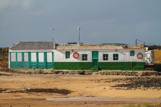 A white and green building in the middle of a field in Fuerteventura, Canary Islands