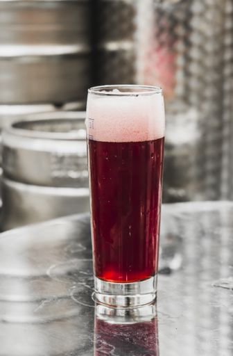 A vertical shot of a glass of Irish red ale in craft brewery