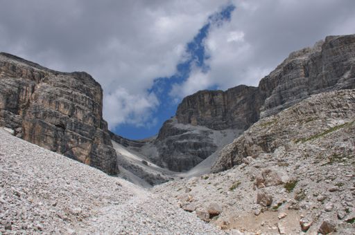 A closeup shot of the dunes and gravels in a rocky valley under blue cloudy sky on a sunny day