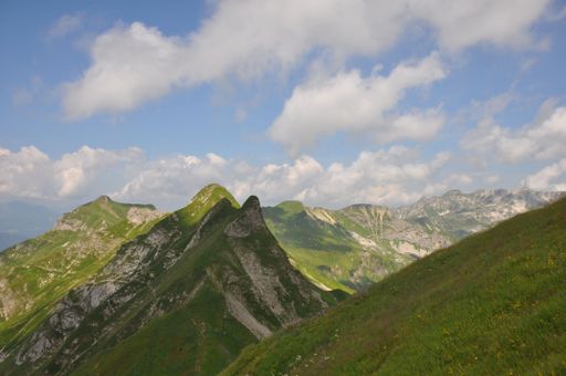 A mesmerizing landscape of grass mountains on a sunny day and under a blue sky