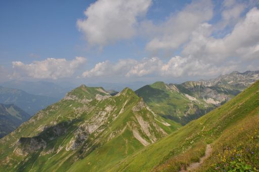 A mesmerizing landscape of grass mountains on a sunny day and under a blue sky
