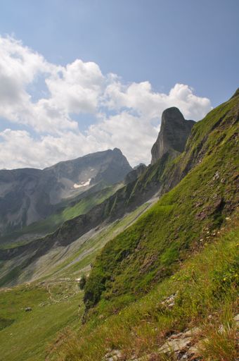 A Beautiful landscape of green valleys and rocky hills under blue cloudy sky