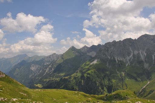 A Beautiful landscape of green valleys and rocky hills under blue cloudy sky