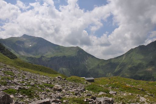 A Beautiful landscape of green valleys and rocky hills under blue cloudy sky