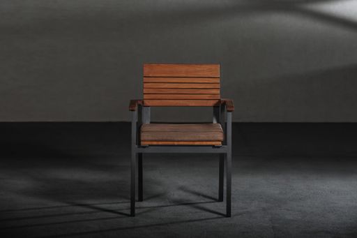 A wooden dining room chair in a studio with gray walls