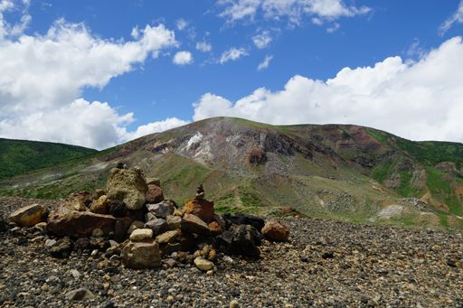 A scenic shot of a volcanic crater and rocky mountains in a sunny day