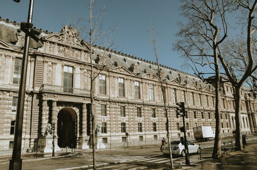 Beautiful landscape shot of the Louvre museum building in Paris, France with a beautiful sunlight.