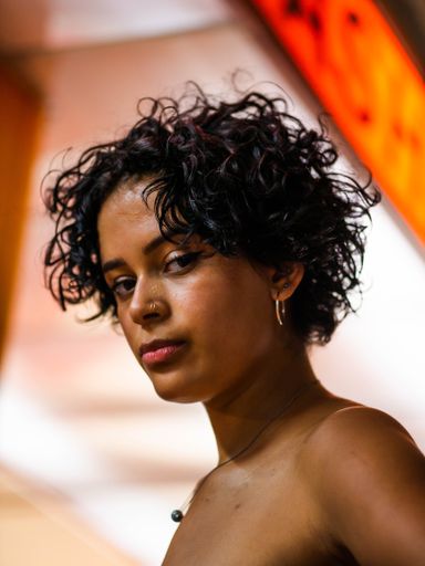 A vertical closeup shot of a beautiful Brazilian female posing at the camera