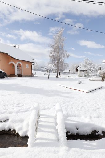 A vertical of a snowy residential area in the countryside in winter