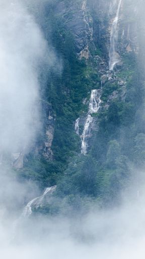 A vertical shot of waterfalls among clouds