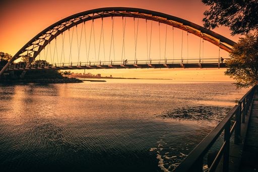 The Humber Bay Arch Bridge seen above Lake Ontario reflecting the beautiful sunset sky