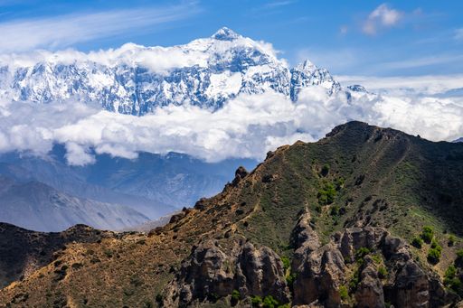 A view of the Annapurna and Nilgiri mountains in the Kingdom of Mustang, Himalaya, Nepal under a clear, blue sky