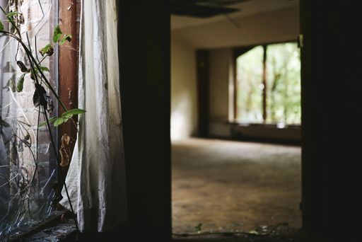 An old, abandoned building interior. Blurry room in the background.