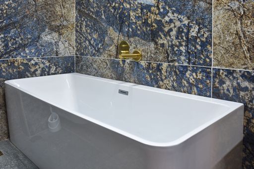 A closeup of a sink with gold faucet in the modern bathroom