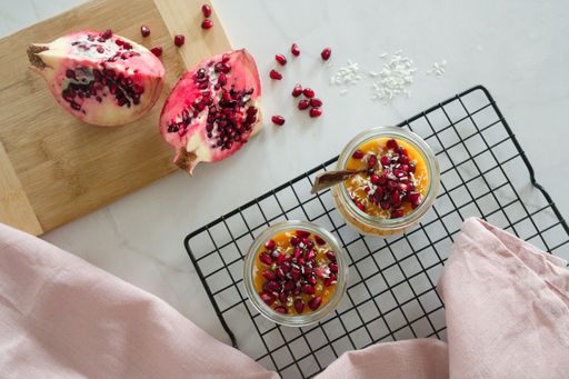 A closeup of healthy breakfast jars with mango puree mixed with chia seeds and pomegranate