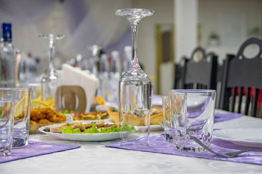 On festive banquet table there are plates with appetizers, cutlery and wine glasses. Beautifully decorated holiday table.